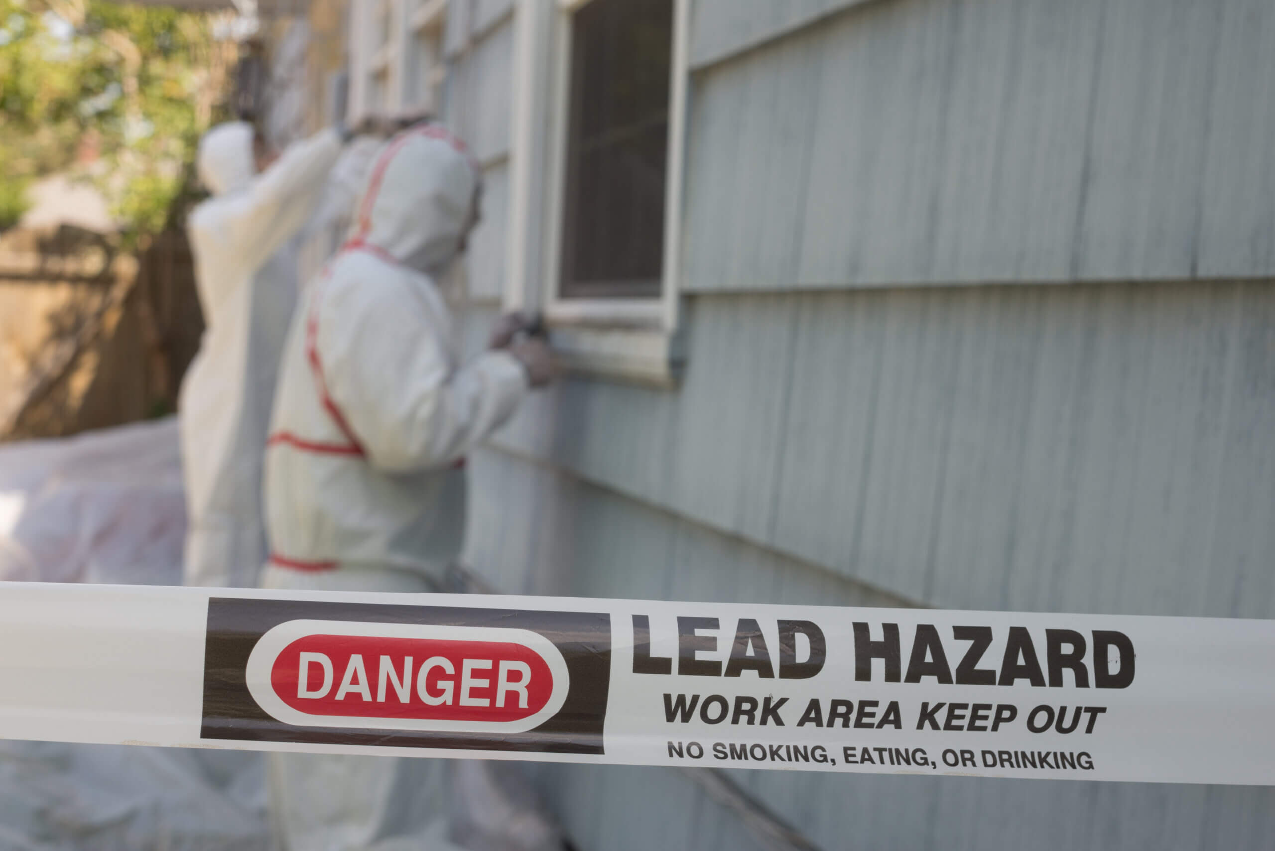 Professionals in protective suits working on a lead abatement project.